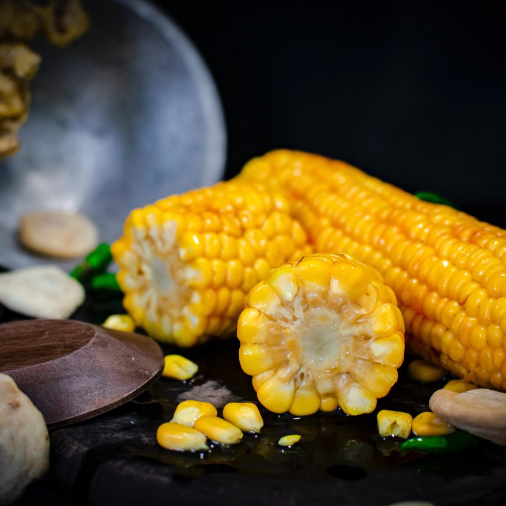 selective focus photography of three yellow corns